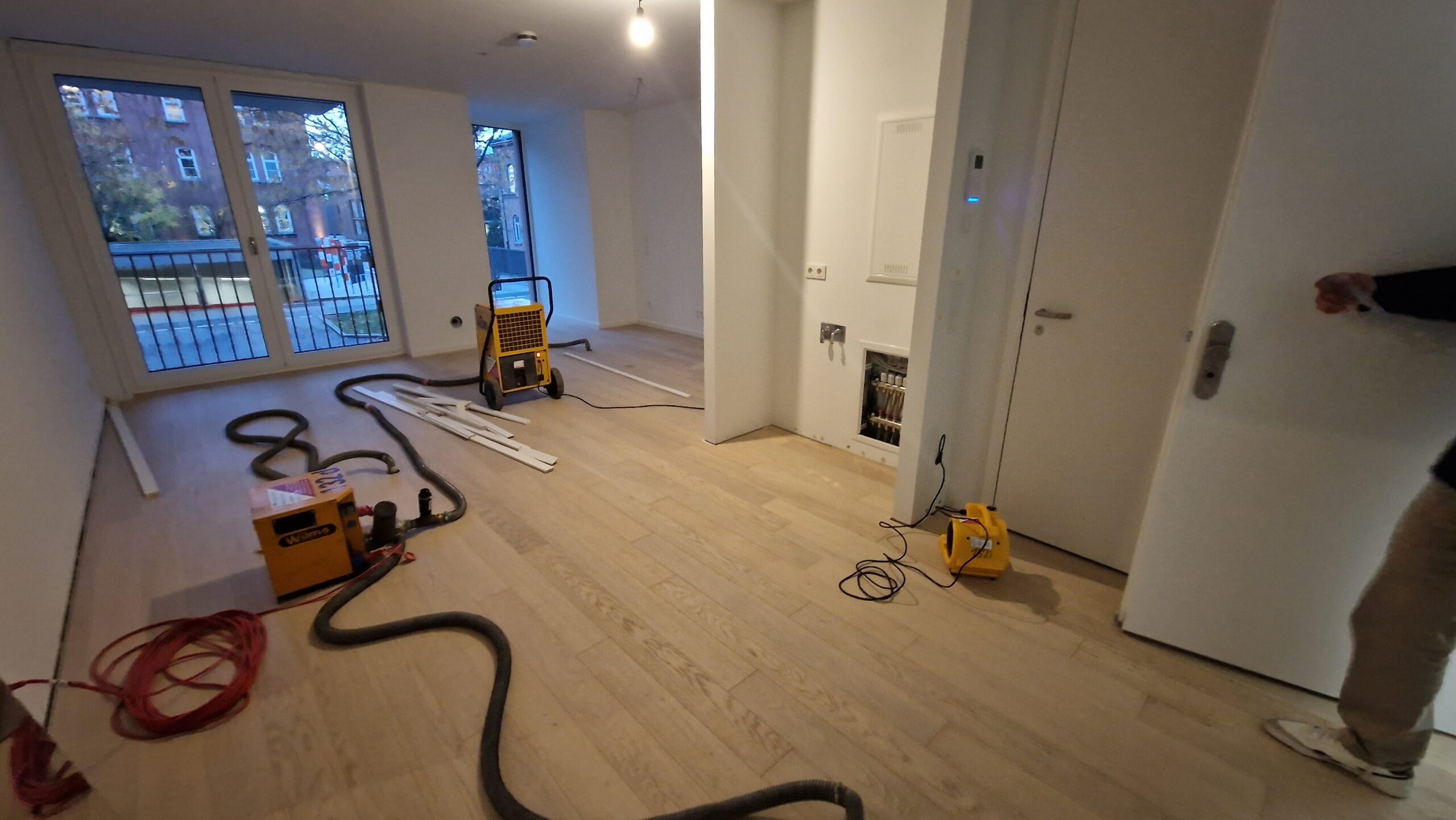 Der Bautrockner steht mit Dämmschichttrockner in einer Neubauwohnung.