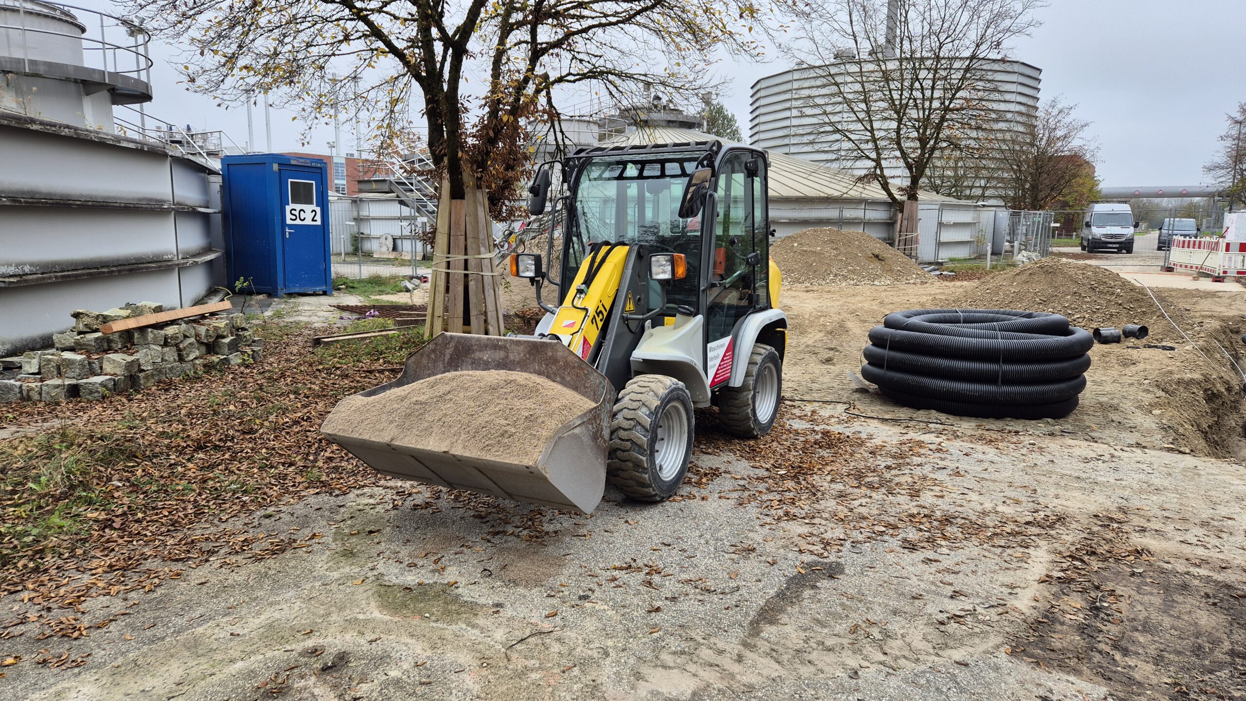 Der Radlader verfährt eine volle Schaufel voll Kies