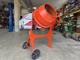 Der Betonmischer steht mit aufgerollter Mischertrommel in der Maschinenhalle