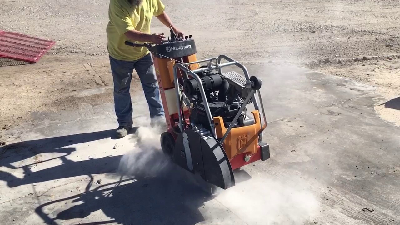 Fugenschneider mit Bediener beim Schneiden eines Betonbodens